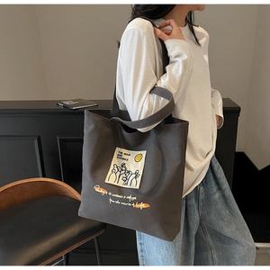 Detail view of large grey canvas tote bag with artistic quote and portrait print