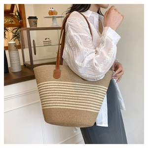 Gros plan sur la texture tissée et les lanières en cuir du grand sac à rayures