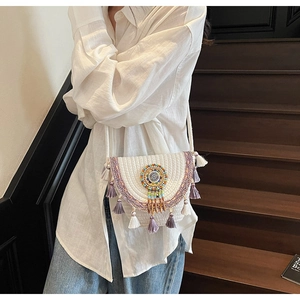Detail of bohemian hand-woven shoulder bag with tassels and colorful beadwork