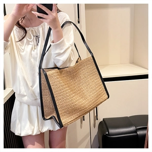 Détail du sac cabas en paille avec bordures en cuir noir et doubles bandoulières