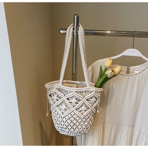 Detail of bohemian cotton woven tote bag featuring hollow diamond pattern and drawstring liner