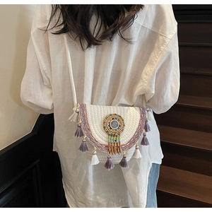 Detailed close-up of Bohemian straw woven crossbody bag with colorful beads and tassels