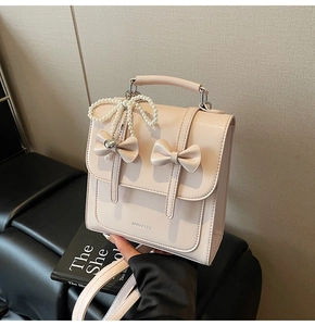 Vue détaillée du sac rose avec des nœuds décoratifs et un pendentif papillon en perles