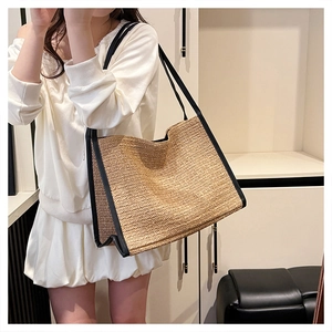 Détail du sac cabas en paille tissée avec bordure en cuir noir et finition en raphia