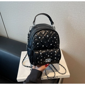 Macro detail of black quilted mini backpack with rhinestone studs and silver twist lock