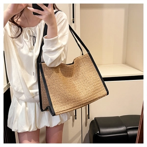 Détail du sac fourre-tout en paille tissée avec lanières en cuir noir et texture
