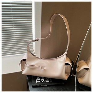 Detail of light pink glossy leather hobo bag with silver zipper and buckle accents