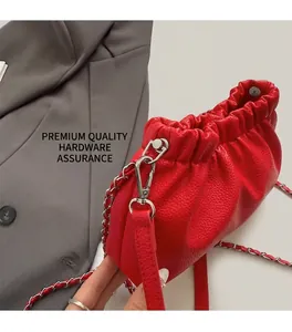 Détail du sac nuage rouge texturé litchi avec chaîne argentée et plis élégants