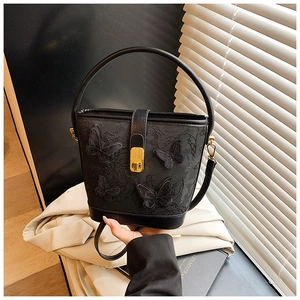 Détail du sac seau noir avec broderie de papillons et fermoir en métal doré