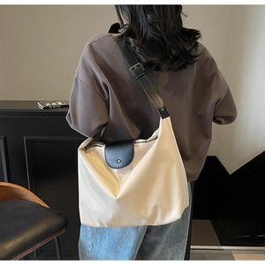 Detail view of large Oxford tote bag with adjustable black leather straps and metal buckle