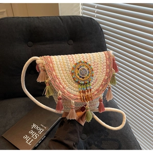 Detail of bohemian woven crossbody bag with colorful fringe and beaded mandala design