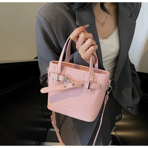 Borsa a mano rosa con trama litchi indossata da modella, tracolla e fibbia in argento