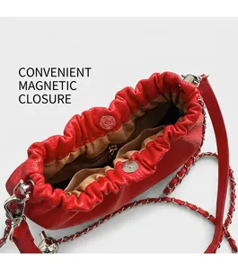 Détail d'un sac seau en cuir rouge avec fermeture magnétique et bandoulière chaîne
