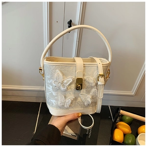 Détail du sac seau blanc avec broderie papillon 3D et fermoir métallique doré