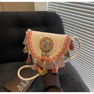 Close-up of bohemian woven bag featuring colorful wave embroidery and silk fringe details