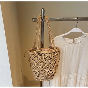 Detail view of cotton rope woven beach bag with hollow geometric pattern and inner drawstring