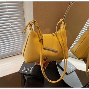 Detailansicht der hellgelben Kunstledertasche mit silberner Schließe und Spiegeleffekt