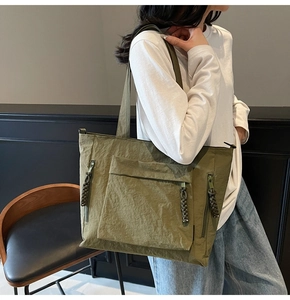 Olive green nylon tote bag featuring functional multiple front zipper pockets for storage