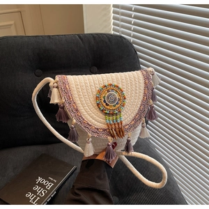 Macro detail of Bohemian woven crossbody bag with colorful beadwork and fringe tassels