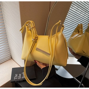 Detail der gelben PU-Schultertasche mit silbernem Metallstab und verstellbarem Trageriemen