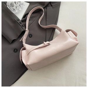 Detail of light pink shoulder bag with side flap pockets and adjustable strap