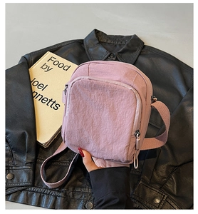 Detail der altrosa Nylon-Umhängetasche mit Doppelreißverschluss und gewebtem Tragegurt