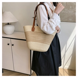 Détail du sac cabas tissé avec anses en cuir marron et motif à rayures horizontales