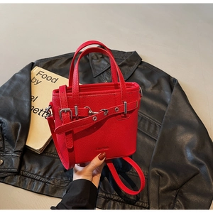 Dettaglio della borsa tote in pelle martellata rossa con fibbia argentata su pelle