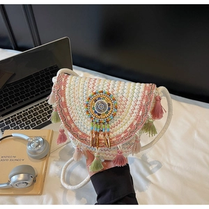 Detail of bohemian woven shoulder bag with colorful tassels and ethnic beaded ornament