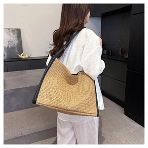 Sac fourre-tout en paille avec finitions en cuir noir et bandoulière sur modèle