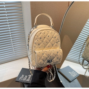 Detail of quilted beige mini backpack with sparkling rhinestones and chain strap