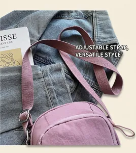 Detail des verstellbaren Stoffriemens und Reißverschlusses der lila Nylon-Umhängetasche