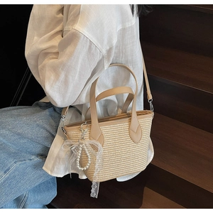 Détail du sac cabas en paille tressée avec lanières cuir et pendentif perle dentelle