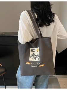 Minimalist dark gray canvas tote bag featuring an artistic portrait print and large capacity