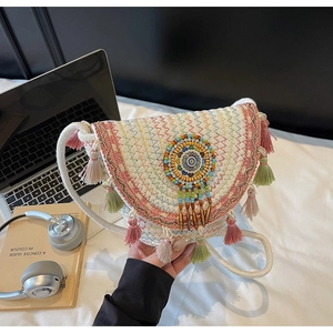 Detail of bohemian woven crossbody bag with colorful tassels and beadwork embroidery