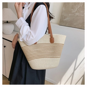 Détail du sac cabas tissé à rayures avec poignées en cuir marron et grande capacité d'usage