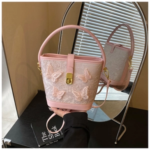 Détail du sac seau en dentelle rose avec broderie papillon 3D et fermoir doré chic