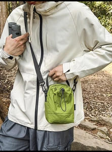 Detail view of grass green nylon bucket bag with drawstring closure and adjustable strap