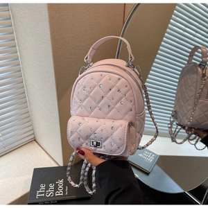 Close-up of pink quilted mini backpack featuring shiny rhinestones and silver turn-lock