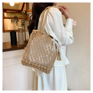 Détail du sac de plage macramé beige avec franges, nœud en dentelle et perles