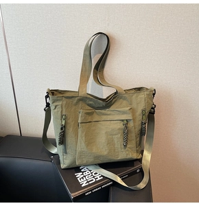 Detail of army green nylon tote bag with rope zipper pulls and adjustable shoulder strap