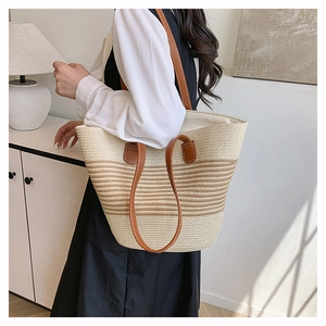 Grand sac cabas tissé à rayures avec lanières en cuir marron porté par un mannequin