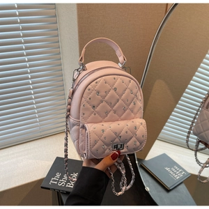 Close-up of pink quilted mini backpack with sparkling rhinestones and chain strap
