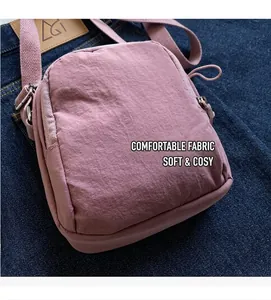 Detail der pinkfarbenen Nylon-Handytasche mit Reißverschlusstaschen und Umhängegurt