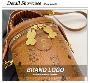 Detail view of brown cylinder bag showing teddy bear print and double bear metal zippers