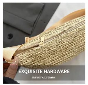 Close-up of woven straw texture with a gold zipper and nylon strap on a beige beach bag