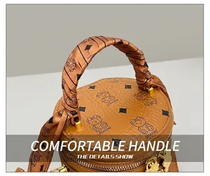 Close-up of brown leather bucket bag with bear patterns and silk scarf handle