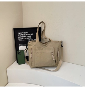 Detailed side view of nylon tote bag with zipper pocket and adjustable shoulder strap