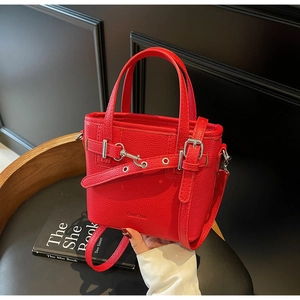 Vista dettagliata della borsa in pelle rossa con motivo litchi e fibbia in metallo argento
