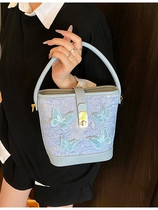 Sac seau bleu clair avec broderie papillon et fermoir rotatif doré élégant